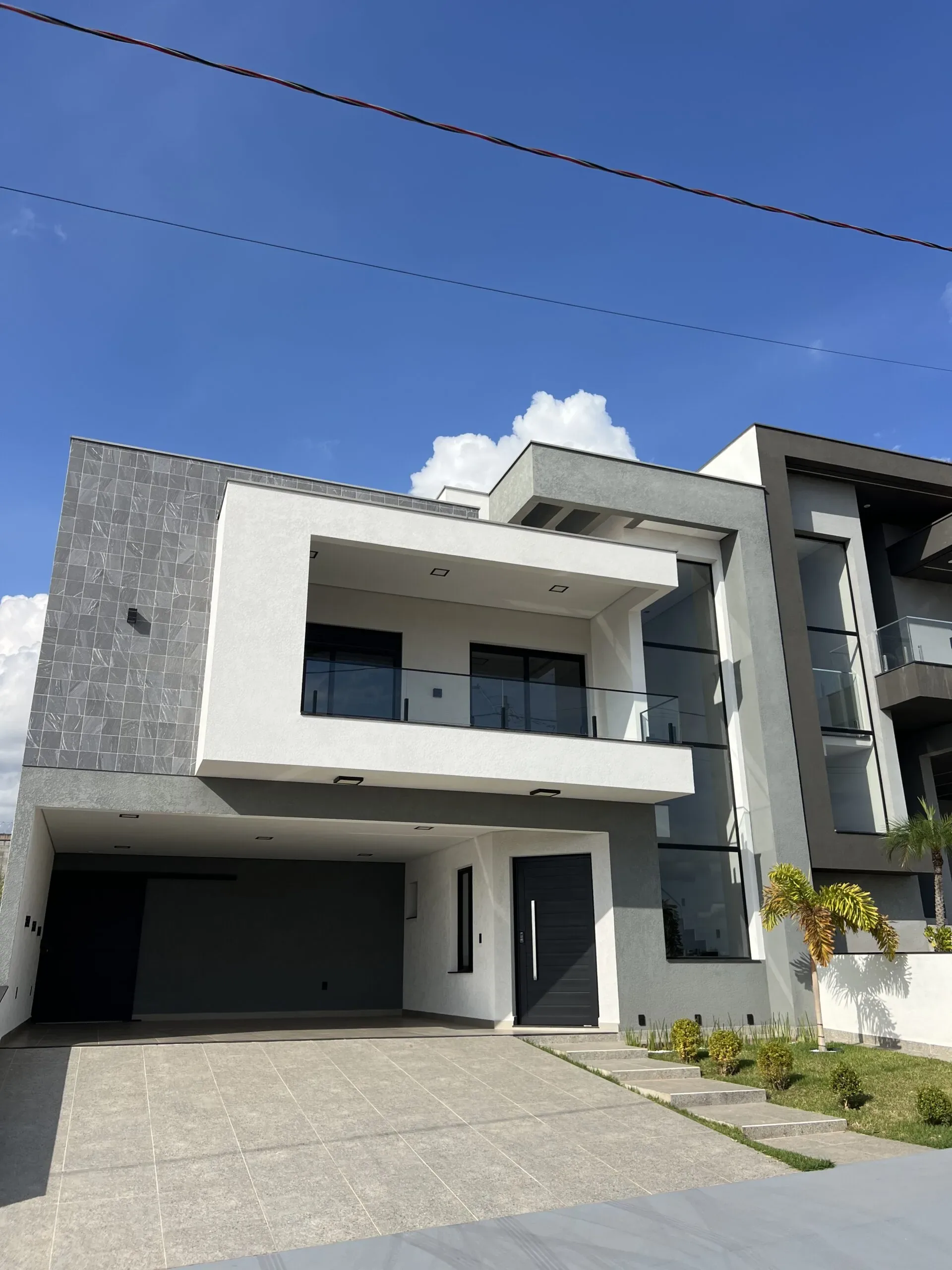 Fachada de residência de alto padrão com esquadrias de alumínio preto, em ângulo alternativo.